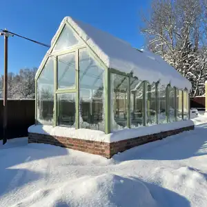 Стеклянная теплица зимой под снегом